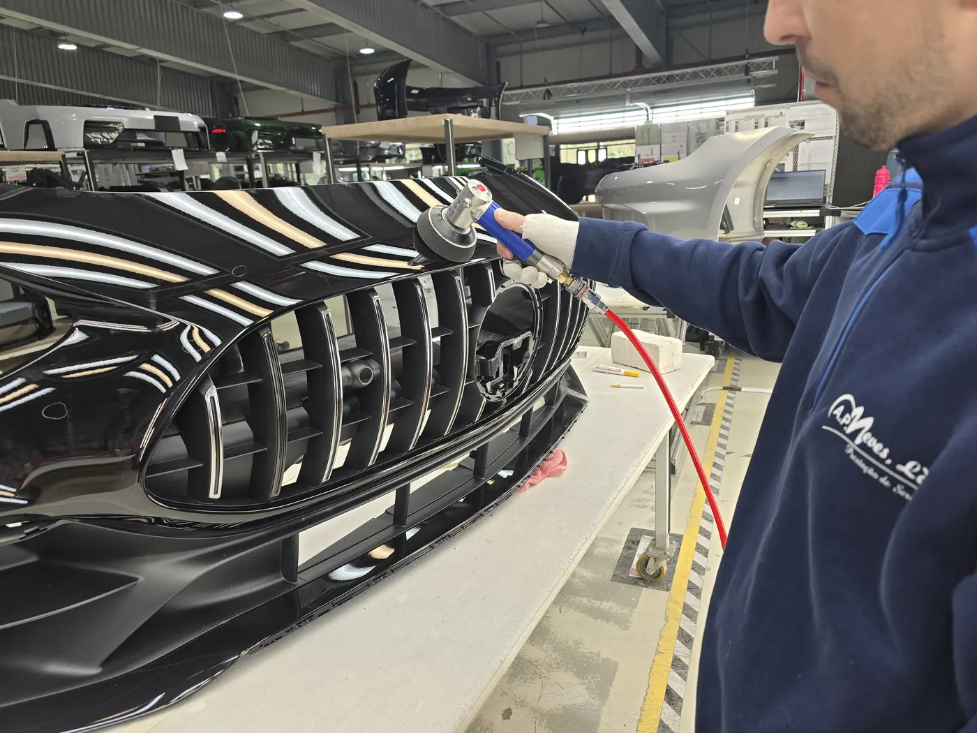AP Neves technician finishing a front bumper with a pneumatic tool